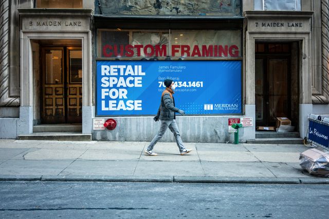 A photo of someone walking by an empty store in Manhattan